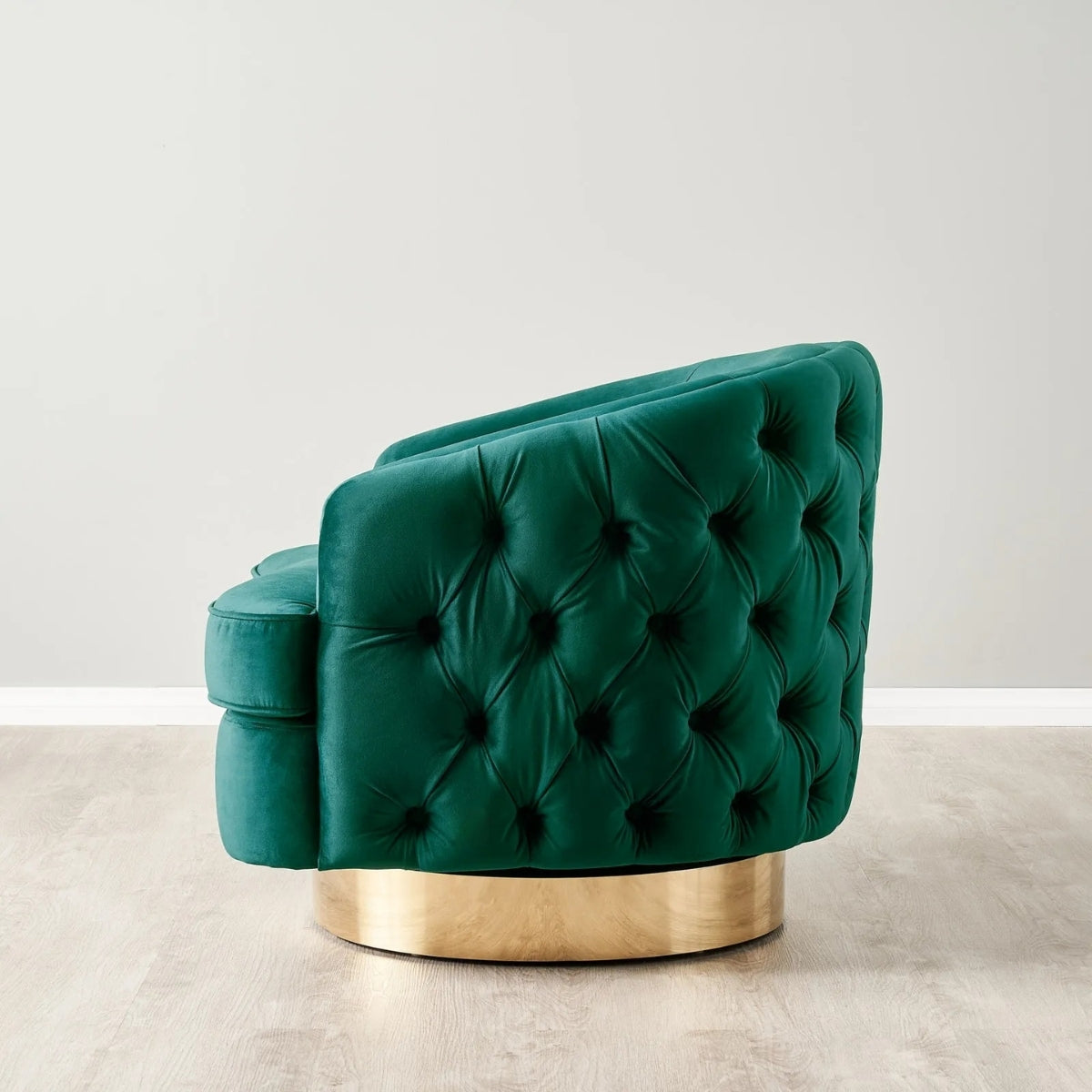 Green tufted chair with gold base on a light background