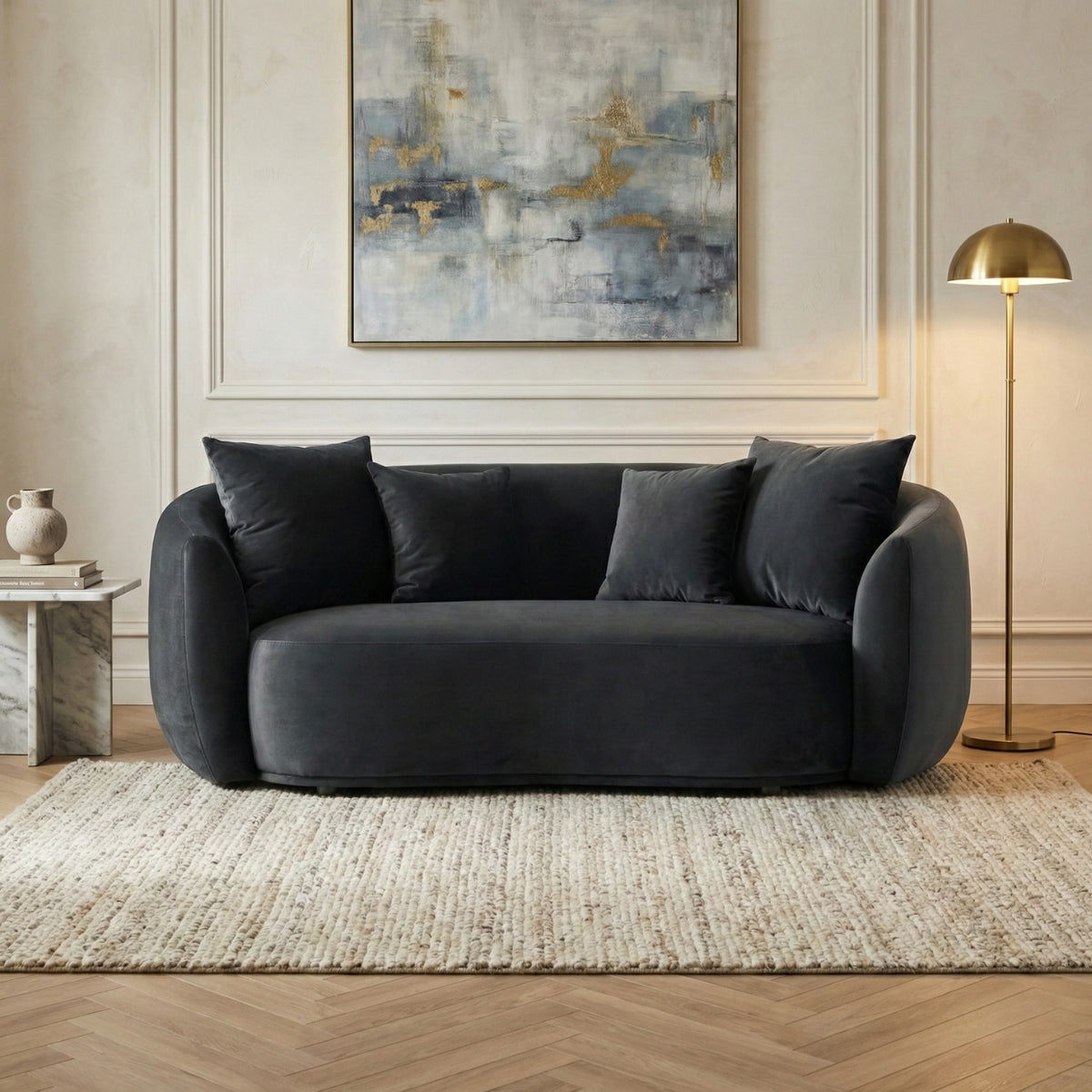 Gray sofa in a living room with abstract art and a lamp.