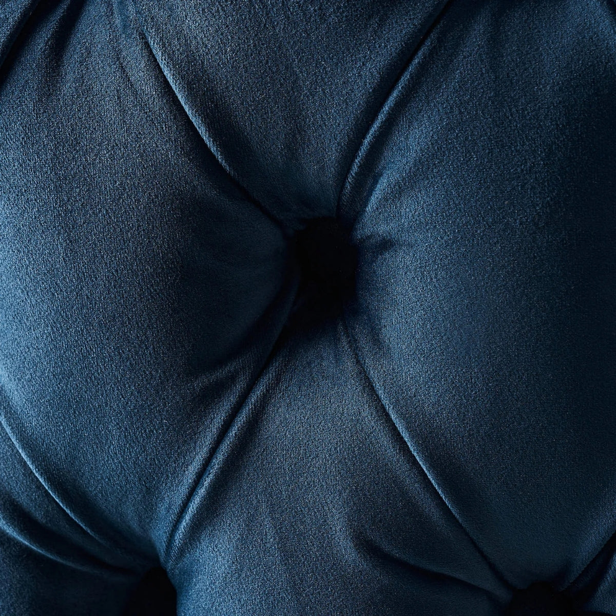 Close-up of a dark blue cushion with a tufted texture
