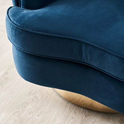 Close-up of a blue velvet armchair on a light wooden floor