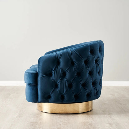 Blue tufted chair with a gold base on a light gray background