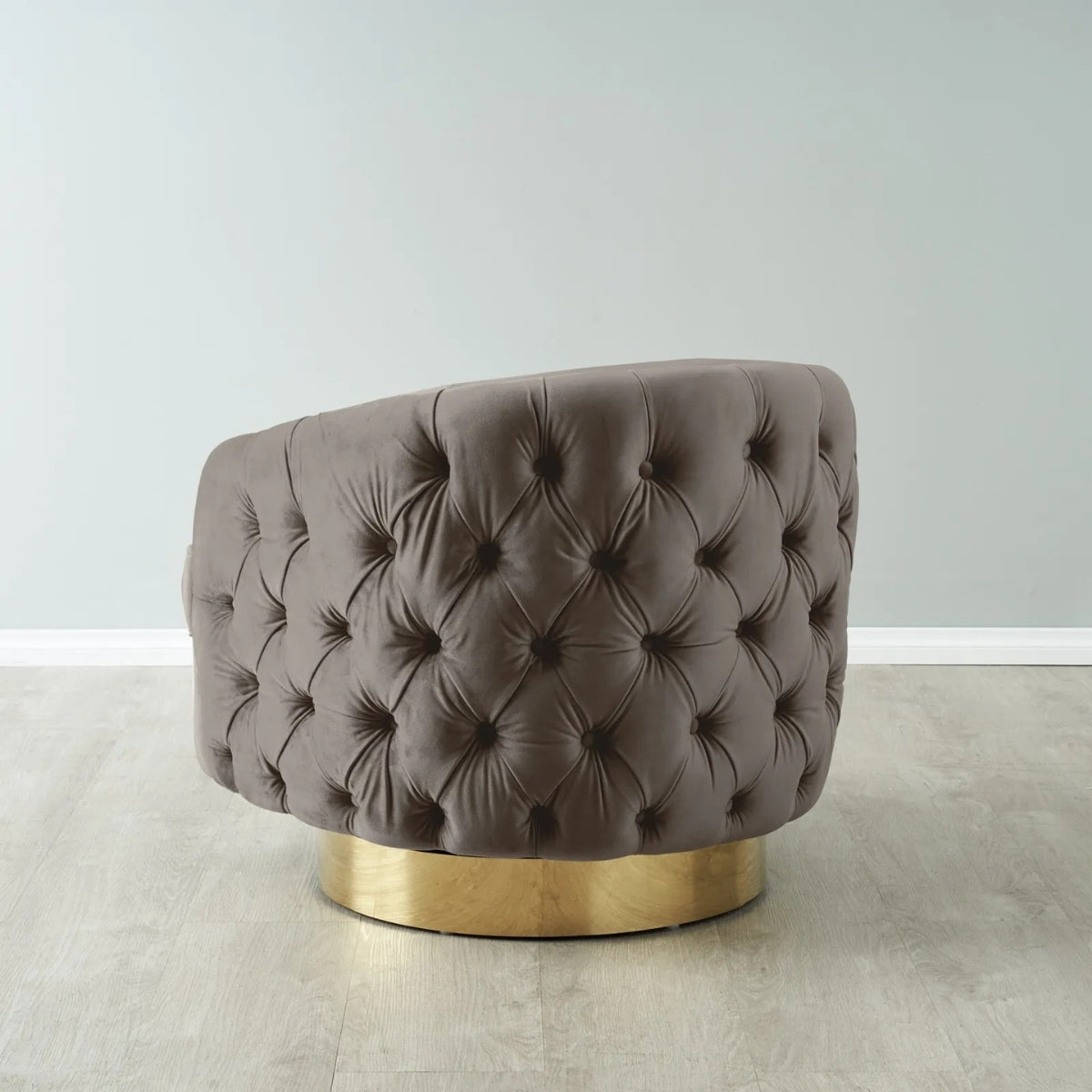 Brown tufted chair with gold base on a light wooden floor.