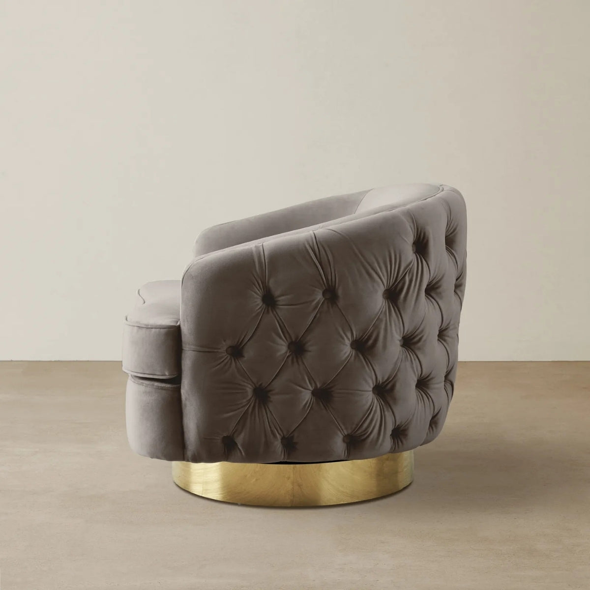 Gray tufted chair with gold base on a beige background