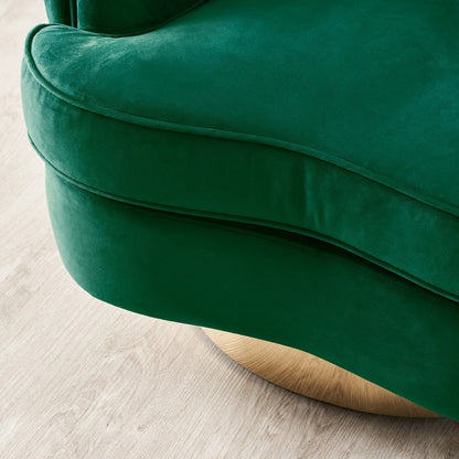 Close-up of a green velvet armchair on a light wooden floor