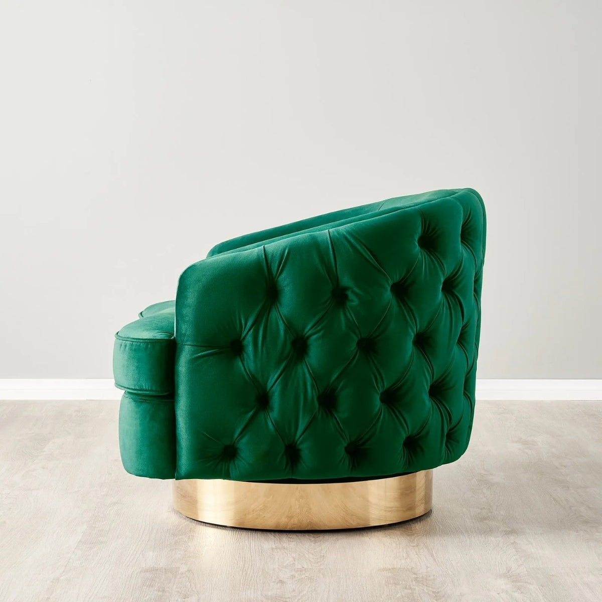 Green tufted chair with gold base on a light gray background