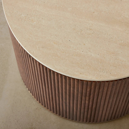 Round table with a textured surface and ribbed base on a neutral background