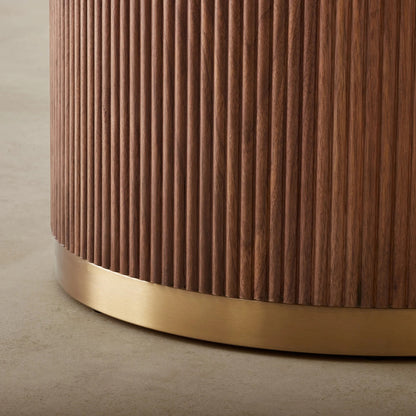 Wooden cylindrical object with a gold base on a beige background