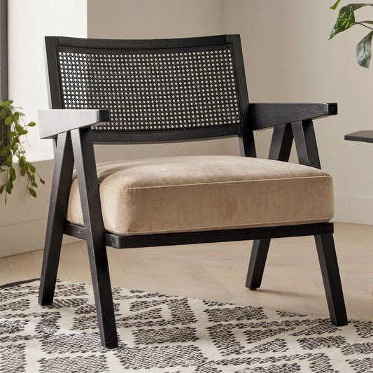 Chair with woven backrest and beige cushion on a patterned rug