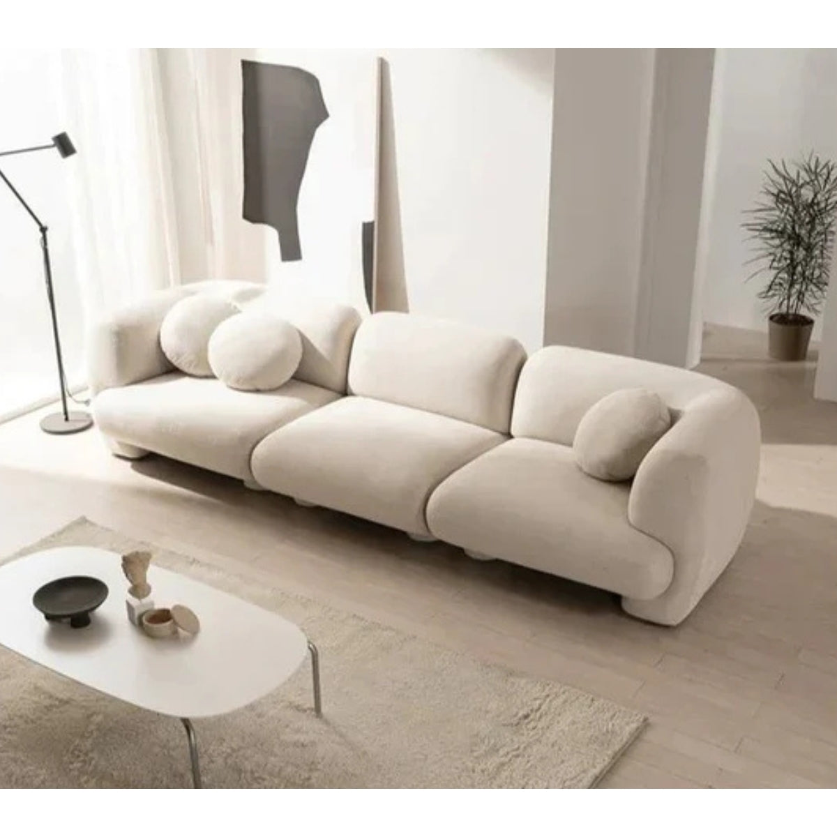 Beige sofa in a modern living room with a white coffee table and decor items.