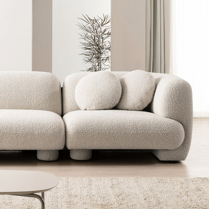 Beige boucle sofa in a modern living room setting with neutral decor.