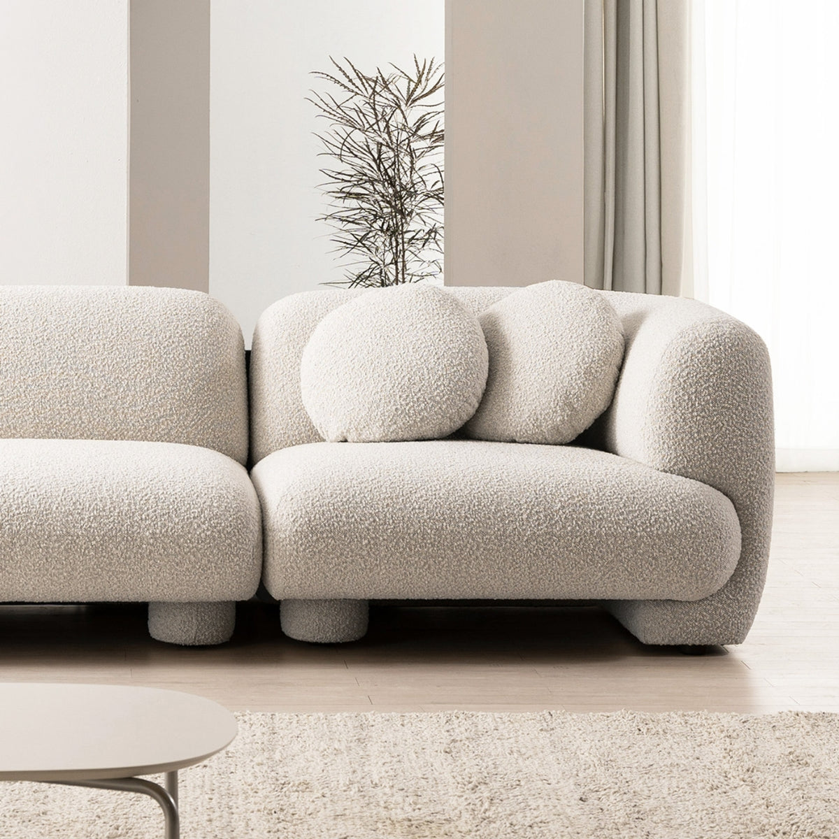 Beige boucle sofa in a modern living room setting with neutral decor.