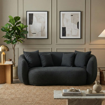 Modern living room with a dark gray sofa, abstract art, and decorative items.