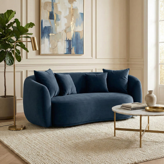 Blue sofa in a living room with abstract art and a coffee table.