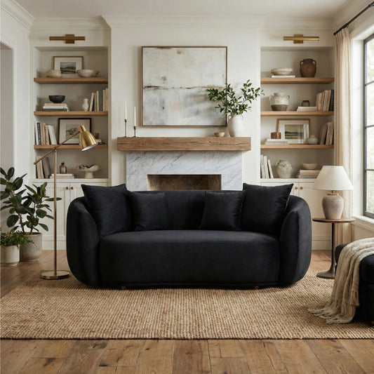 Modern living room with a black sofa, fireplace, and bookshelves.