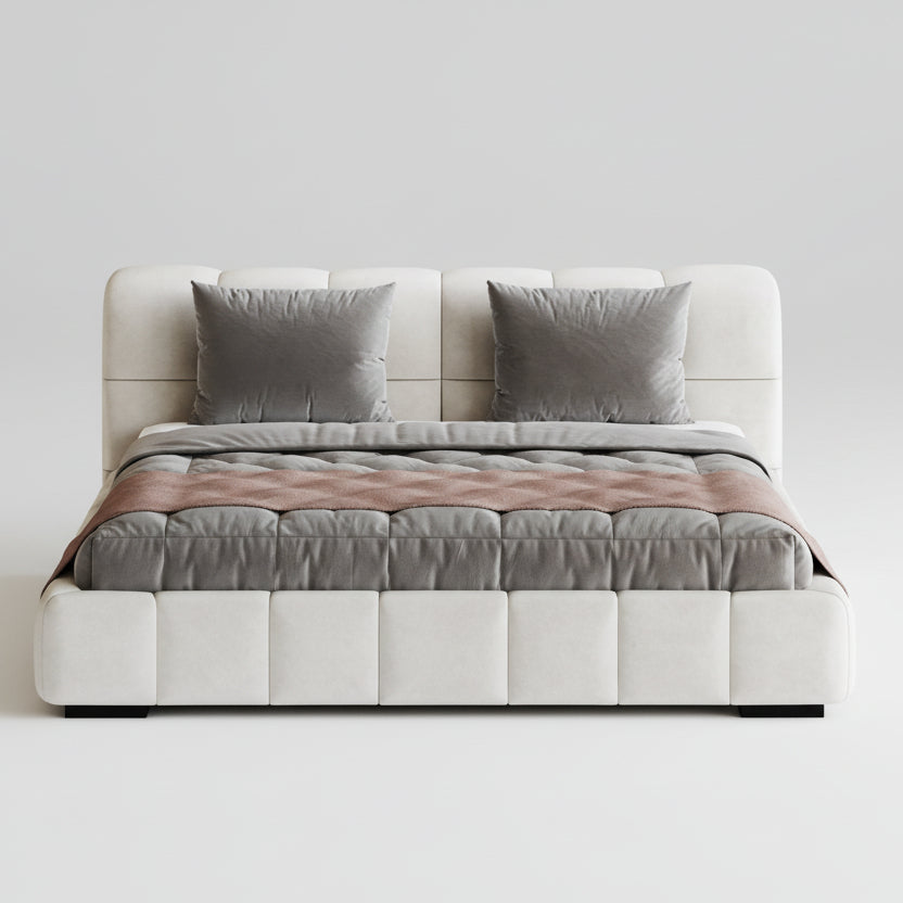 Modern bed with quilt and pillows on a white background